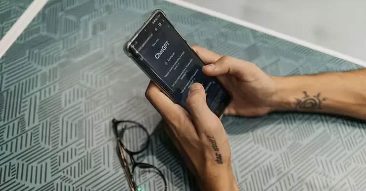 Person using ChatGPT on a smartphone, exploring AI-powered tools for marketing and productivity